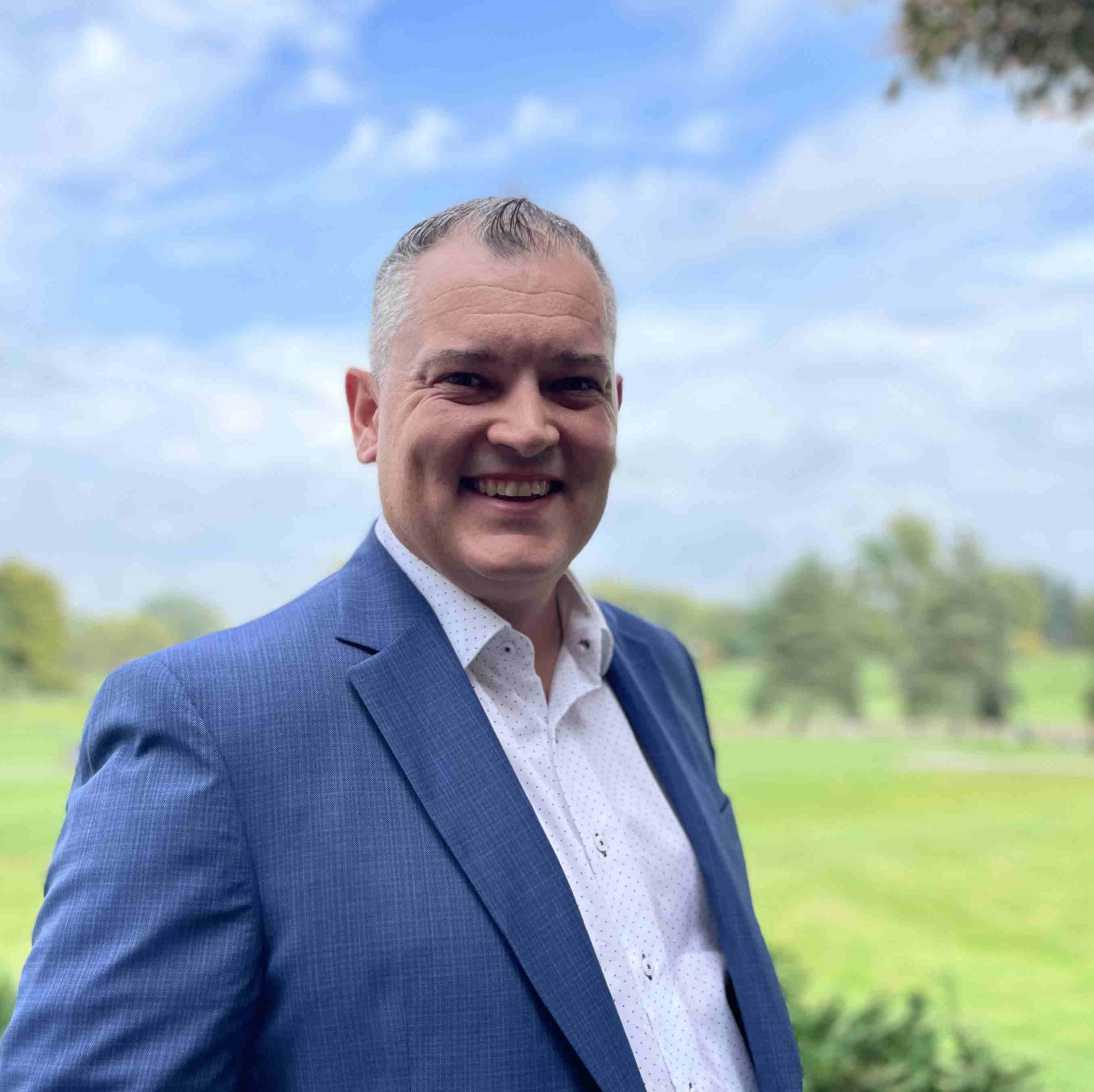 Ryan Keyes, founder of Keyes Advisory Group, in a blue blazer on a golf course